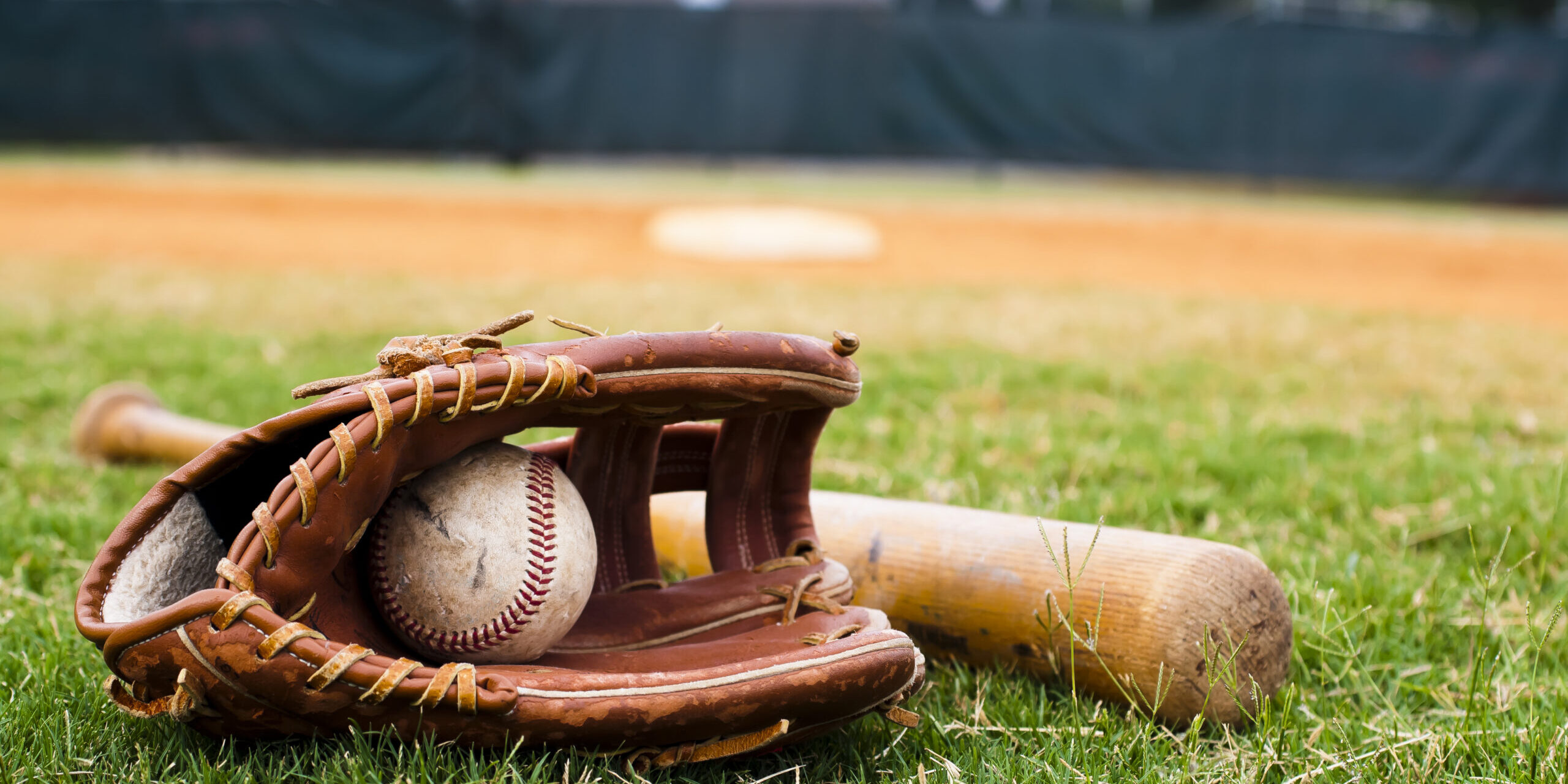Old Baseball, Glove, and Bat on Field