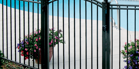 Secure black metal pool fence with decorative flower pots nearby.
